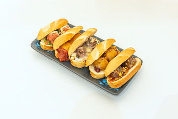 Small sandwiches filled with meatballs with different sauces