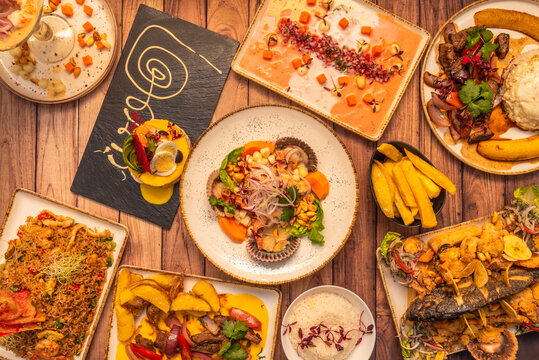 A set of typical dishes that represent Peruvian food with the well-known ceviches, roasted pork loin dishes with rice, corn, sweet potato and battered fish