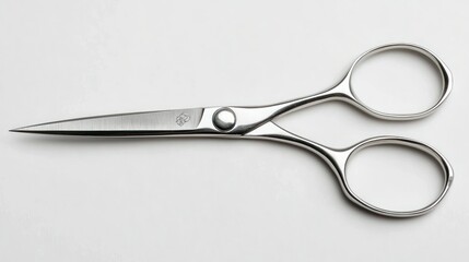 Obraz premium Close-up of a shiny silver pair of scissors with a small logo.