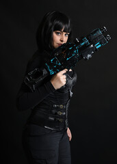 Close up portrait of beautiful black female model wearing black sci fi futuristic dystopian leather bodysuit costume. holding gun weapon. isolated dark studio background moody silhouette.