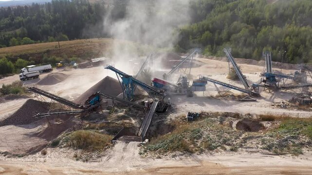  Aerial view of stone jaw crusher plant. Sand making plant and belt conveyor in mining quarry. Sand crushing and bulk materials for construction