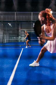 Through the net shot of a doubles female padel match