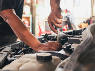 Close up Car Mechanic man hands repairing car auto repair shop. Man hands fixing machinery vehicle mechanical service. open vehicle hood checking up auto mobile. Vehicle Car maintenance engineer.