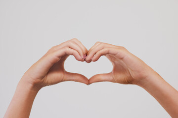 Obraz premium Closeup, heart or hands in studio for love, charity or health insurance isolated on gray background. Peace, fingers or woman with sign for romance, care or show emoji gesture for kindness or donation