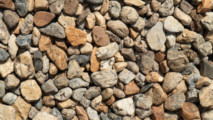 Close-up of assorted pebbles and stones creating a textured and natural background, perfect for design and construction projects.