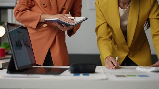 Two businesswomen talking and working Brainstorm ideas for new projects. Calculating operating results Business growth guidelines Online marketing in the modern office.