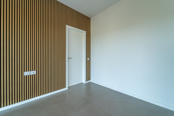 Room with wooden wall texture with wood acoustic panels pattern and white door