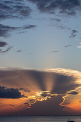 Dramatic clouds with sunlight beams at sunset period, capture from seaside