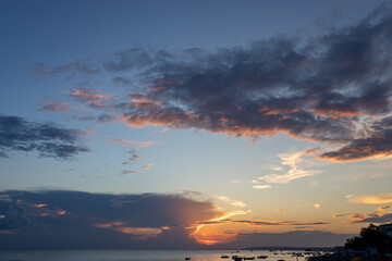 Dramatic clouds with sunlight beams at sunset period, capture from seaside