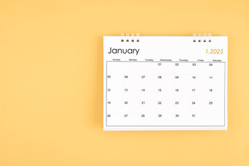 January 2025 desk calendar on yellow color background, position with copy space.