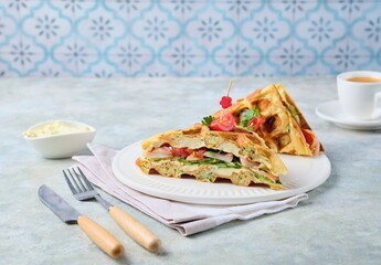 Breakfast, zucchini waffles with cucumber, shrimp, tomato and sauce filling on a gray concrete background. Savory waffle recipes.