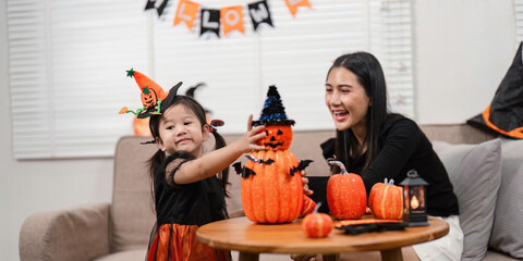 Mother and daughter decorating with pumpkins for Halloween