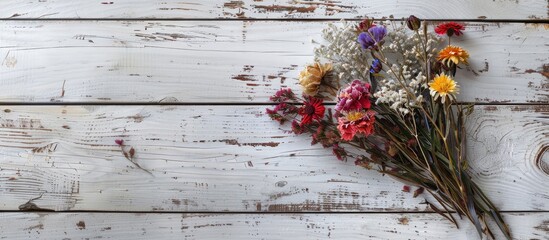 Bouquet of dried flowers displayed on a white weathered wooden surface with a copy space image