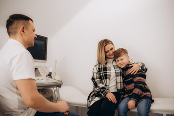 A mother hugs her son at the doctor's office