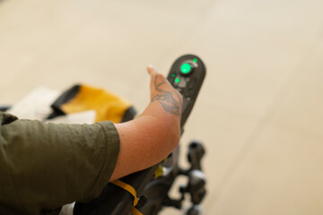 A closeup shows a persons hand using an electric wheelchair controller, highlighting mobility...