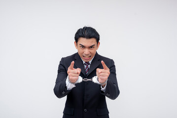 An angry and unrepentant young asian business executive in handcuffs and under arrest vowing to sue...