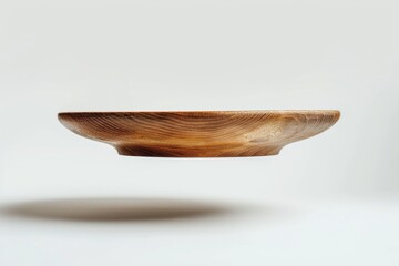 Fototapeta premium A wooden bowl in mid-air, captured in a moment of surprise or action