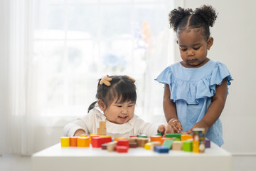 Two diverse children playing with colorful wooden blocks early childhood education, learning and development fun activities for kids in preschool, creative playtime, cognitive growth, friendship