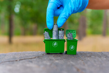 Hand In Blue Gloves Collecting Batteries For Recycling