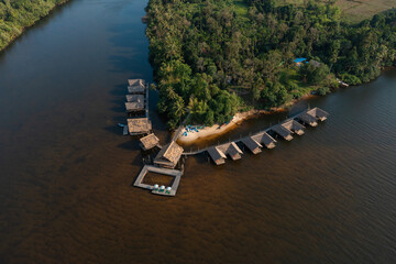Riverside Eco-Resort with Floating Cottages Surrounded by Dense Forest

