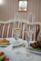 Wedding glasses are stylishly decorated and filled with champagne.