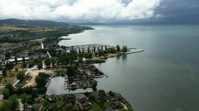 Push in drone shot of the Lake Neuchatel with the port of Estavayer-le-Lac in Canton of Fribourg in Switzerland.