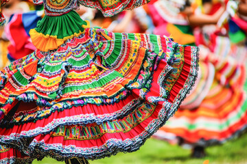 Hispanic dancers swirl in vibrant, traditional dresses, celebrating culture, movement, and heritage