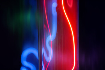 A glass tube with red and blue light from the gas.