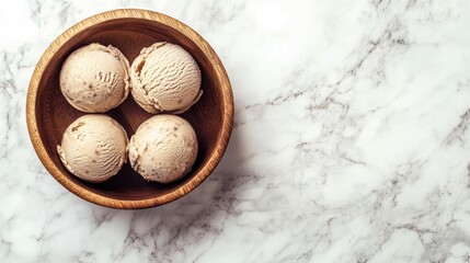 Four scoops of vanilla ice cream in a wooden bowl on a marble background.