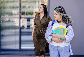 Education, pupil and student, mother and teen girl outside school. private teacher and child with backpack. Family help. mother and teenager daughter with backpack and notes. Back to school.