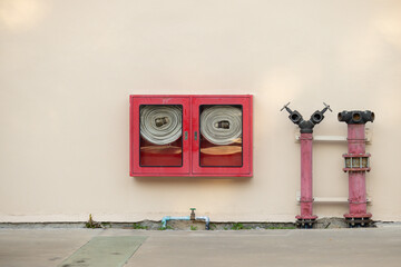 A red fire hydrant is next to a red fire hydrant cabinet
