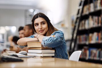 Education, studying and woman in library, thinking and smile for learning, books or university. Scholarship, student and contemplating for knowledge, pile and Indian person in college, ideas or relax