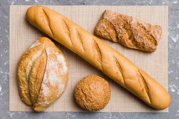 Assortment of freshly baked bread with napkin on rustic table top view. Healthy unleavened bread. French bread