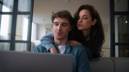 Caucasian woman female girl wife girlfriend hugging man back discuss shopping computer talk choose purchase order delivery tickets booking laptop man male guy boyfriend husband couple talking home - Powered by Adobe