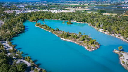 Fototapeta premium Aerial view of turquoise lake surrounded by natural landscape