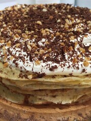 Chocolate Crepe Cake topped with cream, nuts and chocolate curls