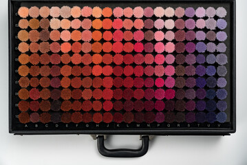 Collection of carpet textile samples in suitcase. Colour gradient variation. Textile industry concept.