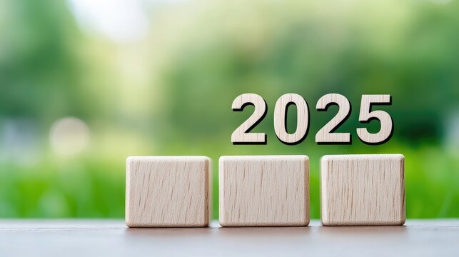 Wooden cubes with the number 2025 set against a soft, blurred green backdrop symbolizing the anticipation of a new year ahead
