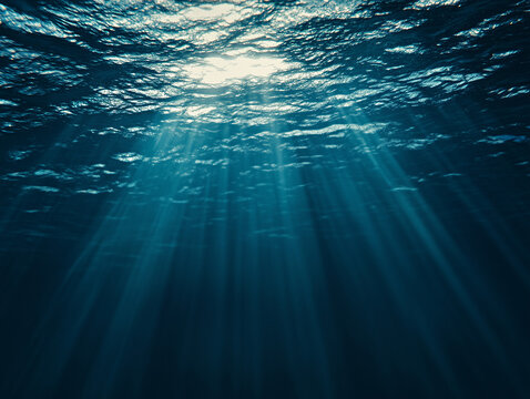 A serene underwater scene with sunlight piercing through the surface of the water, casting soft, diffused rays that illuminate the deep blue ocean below
