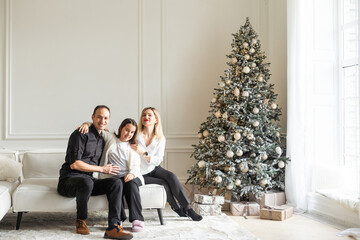 Obraz premium Happy family on bed on a bright Christmas morning. New Year 2025.