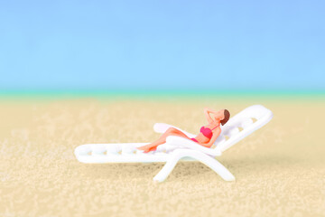 Mini world: Woman Relaxing on Lounger with Beach Background