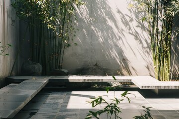 A minimalist outdoor seating area, partially in shade, next to tall green bamboo plants, creating a serene and calming atmosphere.