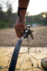 A man is holding a bow and arrow, with his arm extended