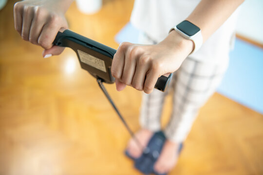 Woman weighing herself on a body fat scale.