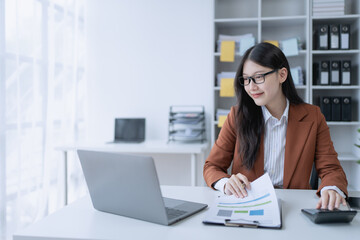 woman meticulously plans a finance audit, using a computer and calculator to review budget...