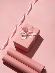 gift with ribbon in pink wrapping on peach background