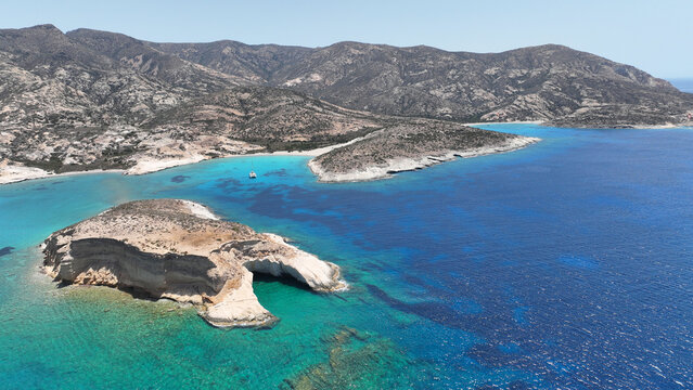 Aerial drone photo of paradise blue bay of uninhabited island of Polyaigos with turquoise crystal clear sea visited by luxury yachts and sail boats resembling a blue lagoon, Cyclades, Greece