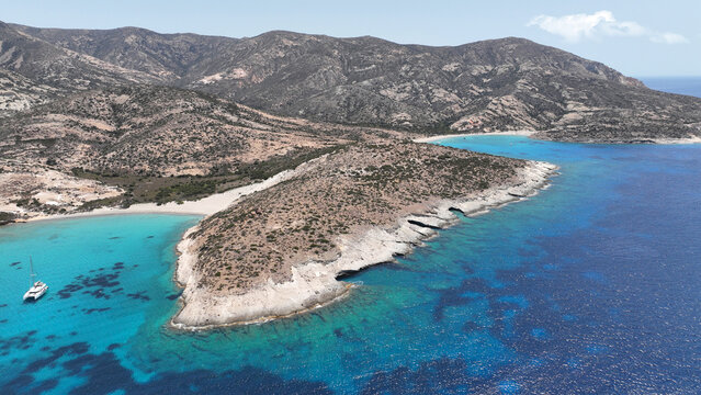 Aerial drone photo of paradise blue bay of uninhabited island of Polyaigos with turquoise crystal clear sea visited by luxury yachts and sail boats resembling a blue lagoon, Cyclades, Greece