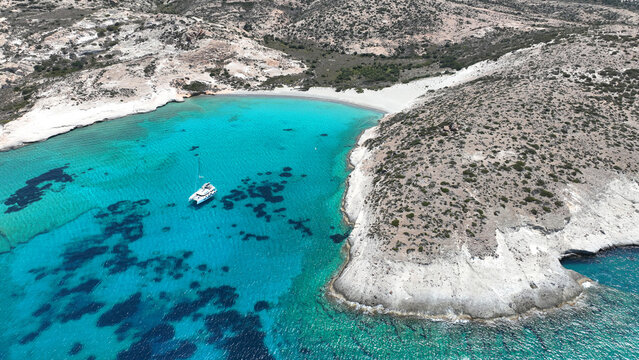 Aerial drone photo of paradise blue bay of uninhabited island of Polyaigos with turquoise crystal clear sea visited by luxury yachts and sail boats resembling a blue lagoon, Cyclades, Greece