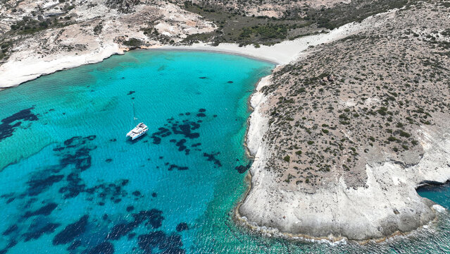 Aerial drone photo of paradise blue bay of uninhabited island of Polyaigos with turquoise crystal clear sea visited by luxury yachts and sail boats resembling a blue lagoon, Cyclades, Greece